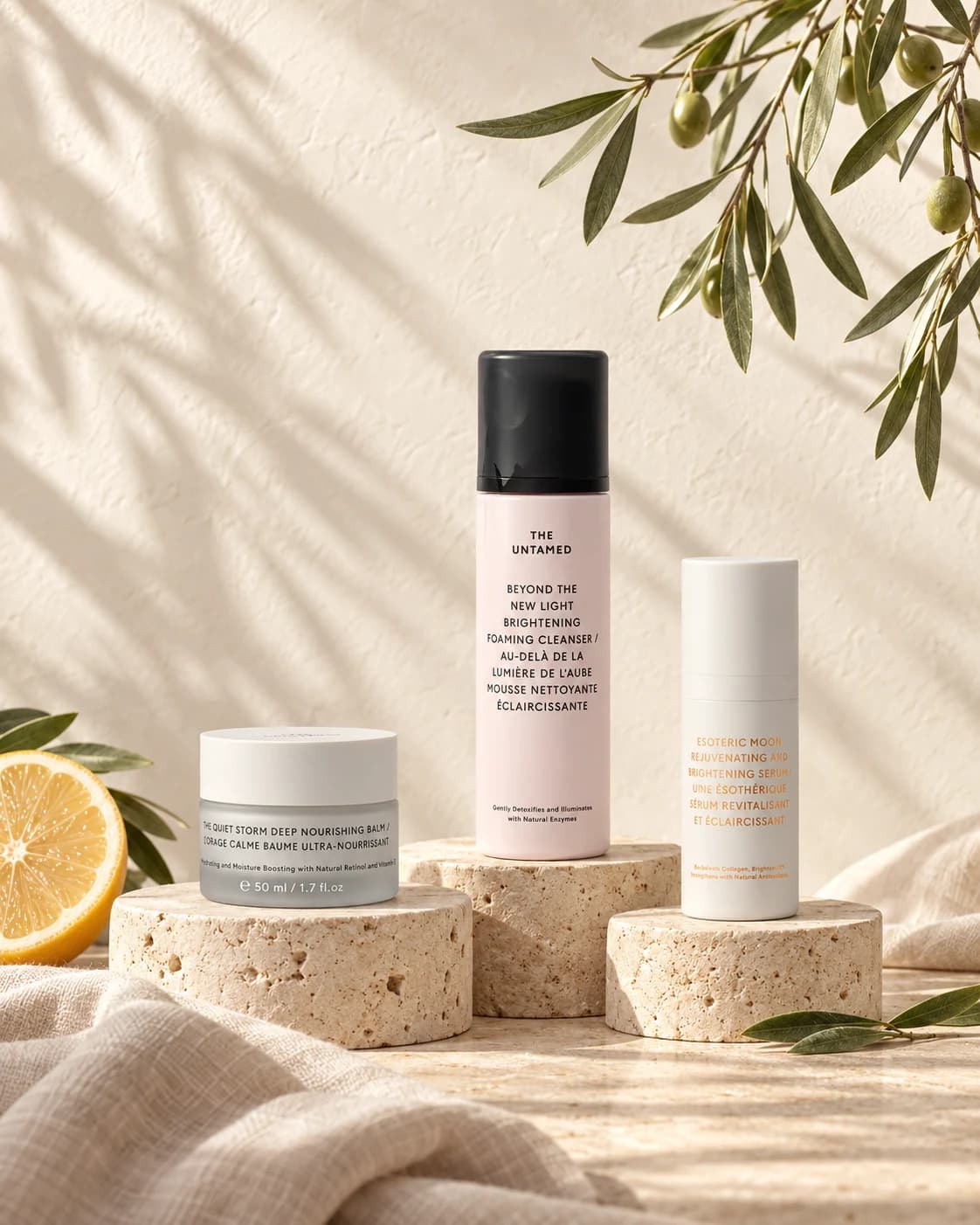 The Untamed cleanser, serum and balm on sunlit stone with fresh botanicals